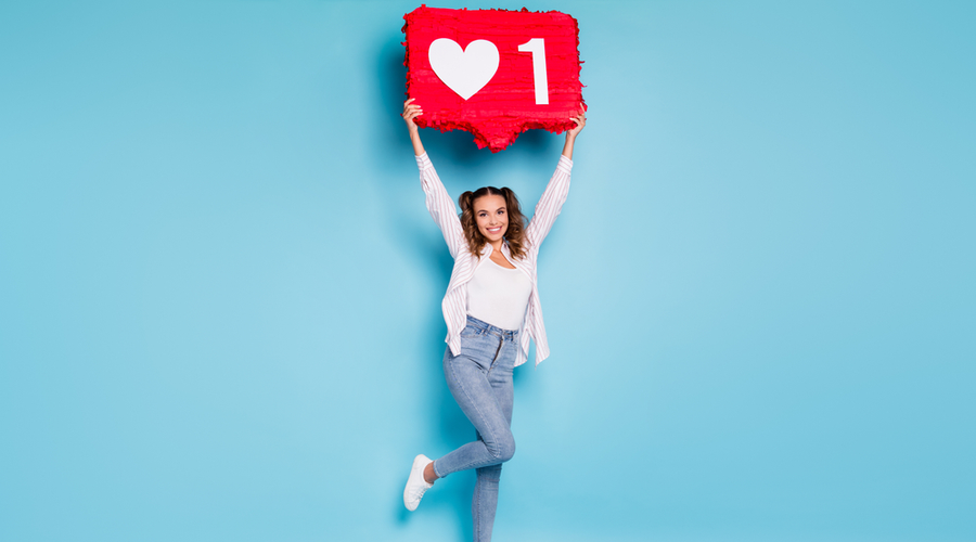 Woman smiling holding like button over her head