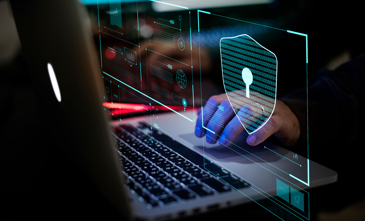 Keyboard with hand about to touch as if about to use for cyber attack