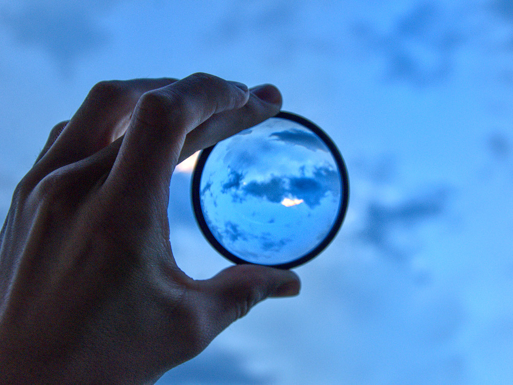 Hand holding up a lens to bring clarity to the user