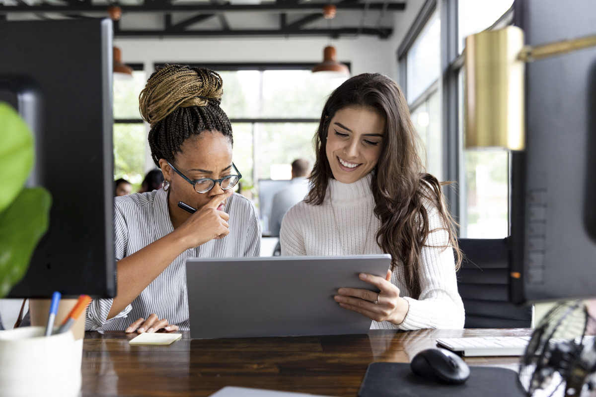 Two people collaborating in front of a laptop