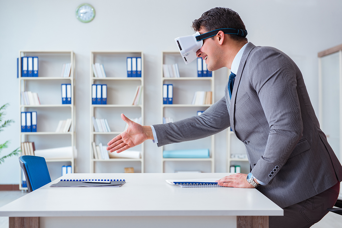 future of work man shaking hands with no-one as he wears a virtual reality headset