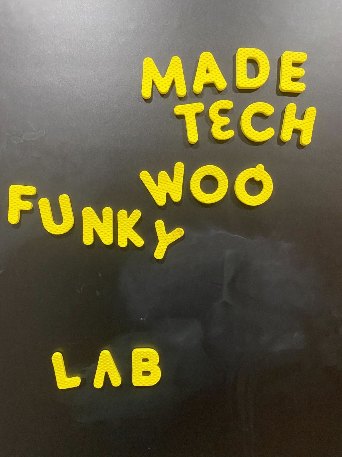 Magnets on a metal wall spell "Made Tech woo funky lab"