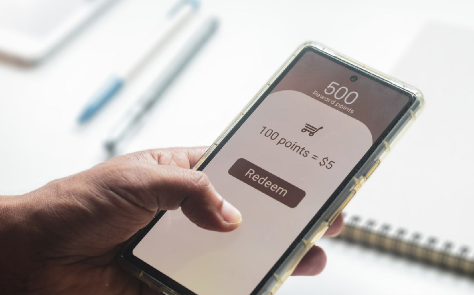 A person holding a phone, redeeming rewards points online.
