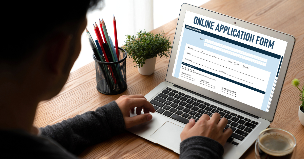 Person typing on a laptop displaying an online application form for professional or public sector submissions