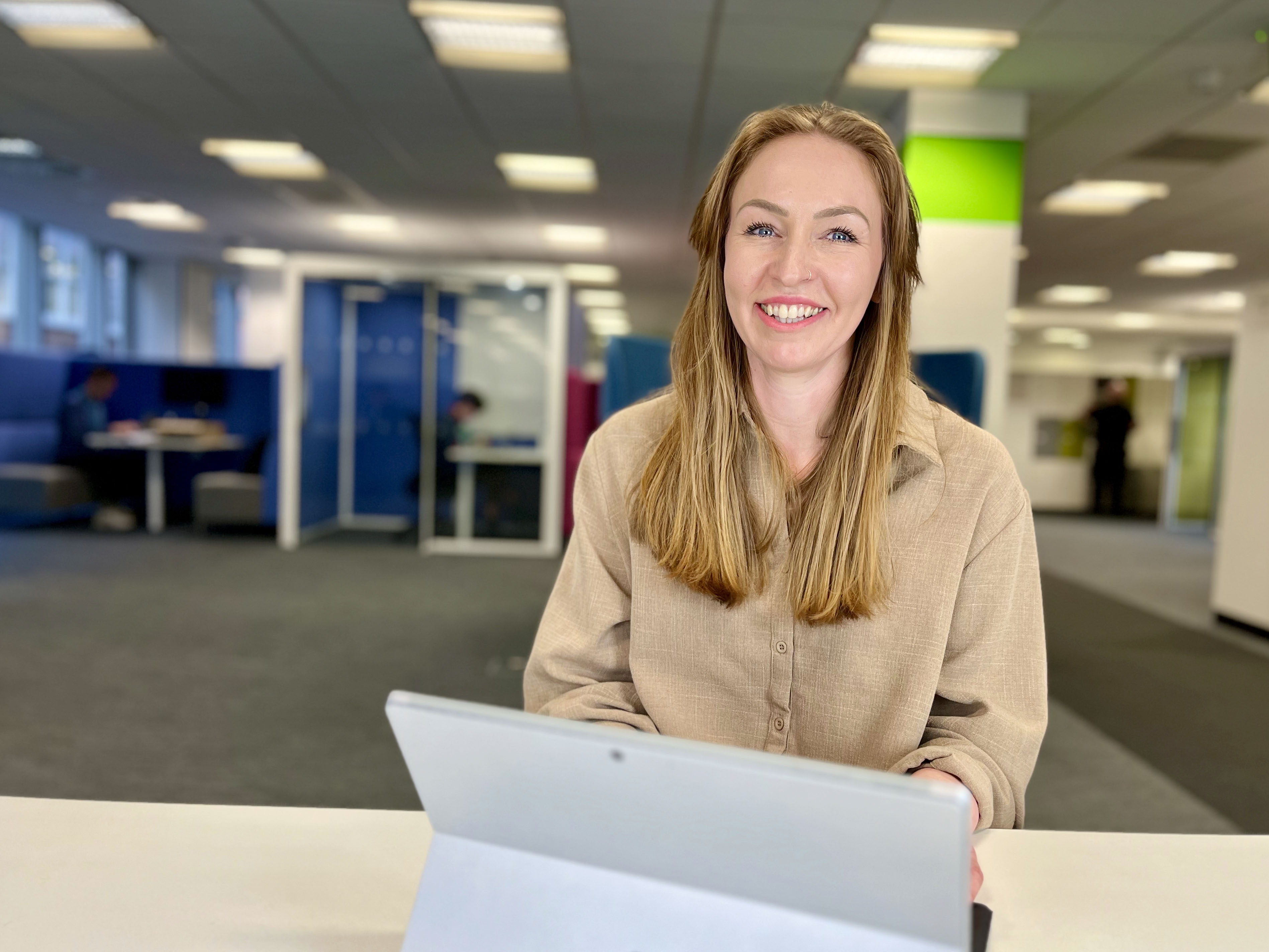 Woman smiling at a desk with laptop