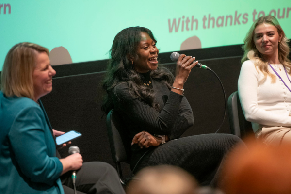 Three women on stage at an event