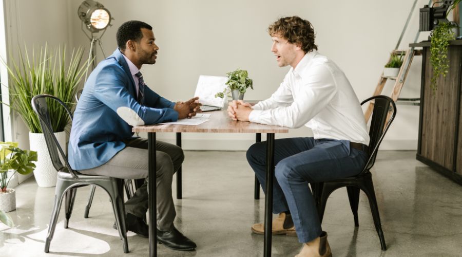 Two males talking at a desk