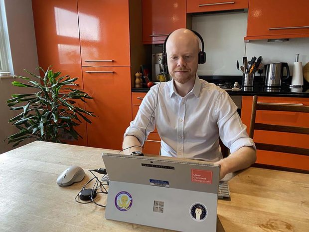 Man working on a DfE Digital laptop at a kitchen table