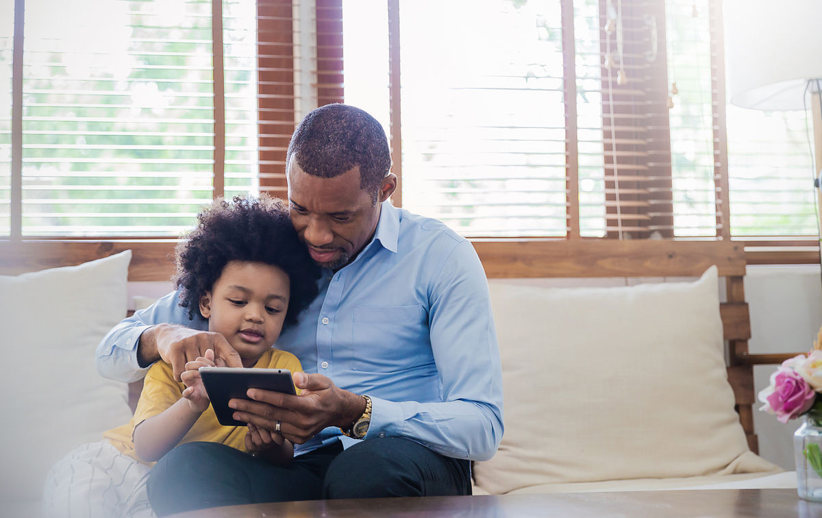 Parent reading to child on tablet device